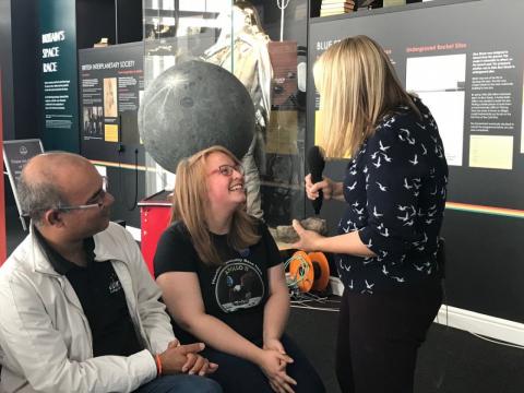 A woman engages in conversation with two men and another woman in a casual setting