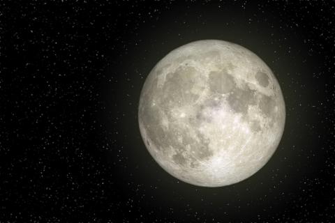 The moon illuminates the night sky, casting a soft glow against the dark backdrop of stars.