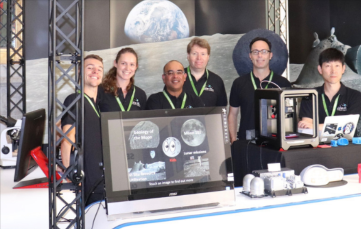 A diverse group of people gathered around a computer, engaged in discussion and collaboration.