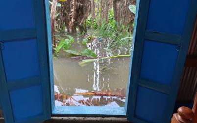 A group of individuals wearing lab coats and gloves, engaged in a scientific discussion in a laboratory setting